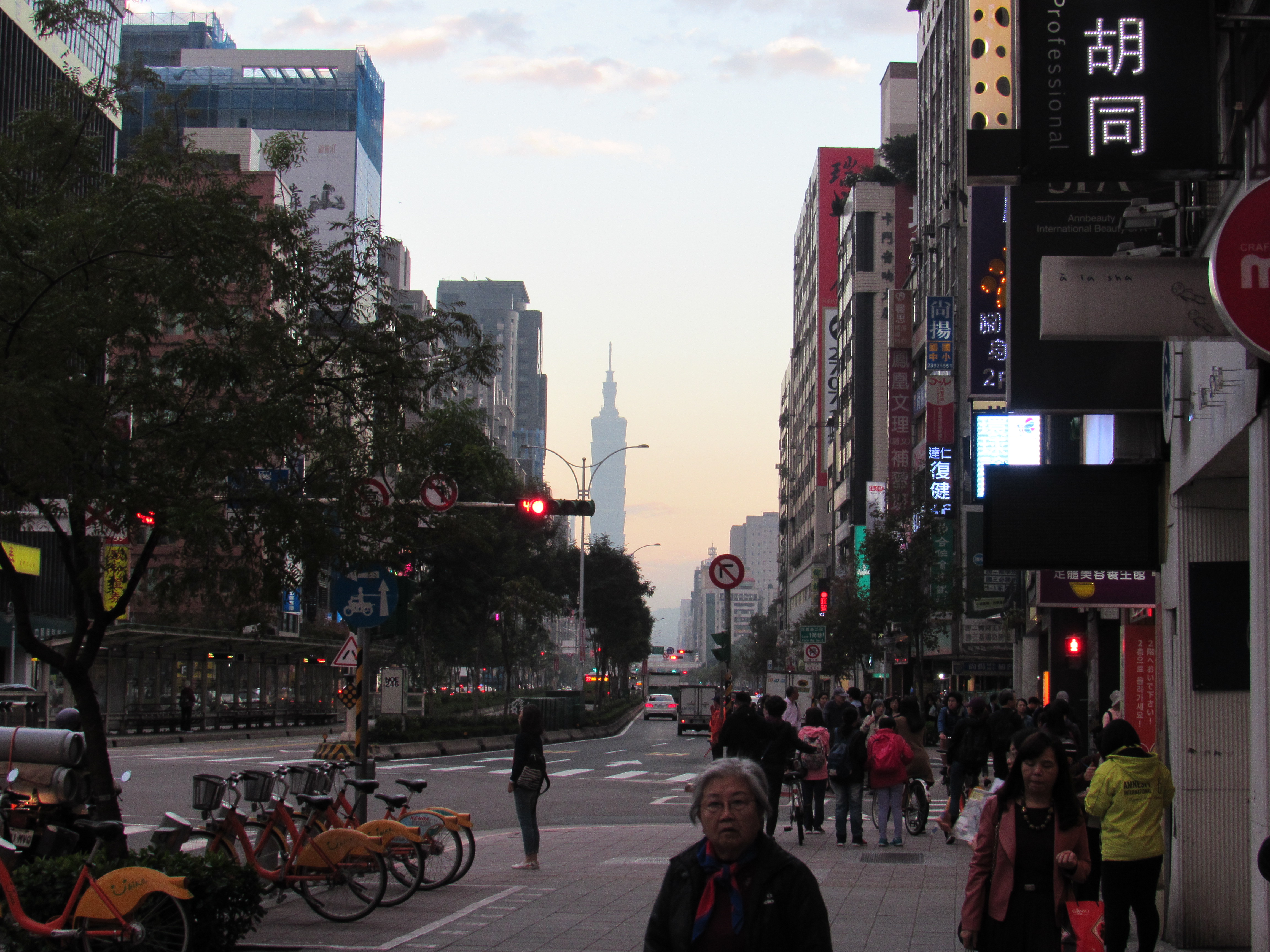 The streets of Taipei at dusk, with Taipei 101 visible in the distance.