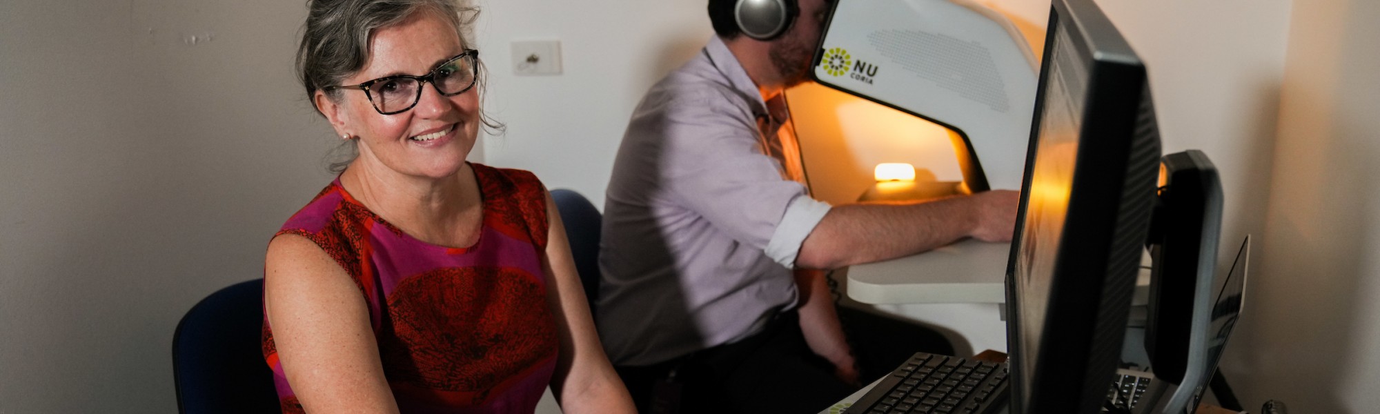 Sarah Mann sits at her computer while a student completes her pupilometry study. 