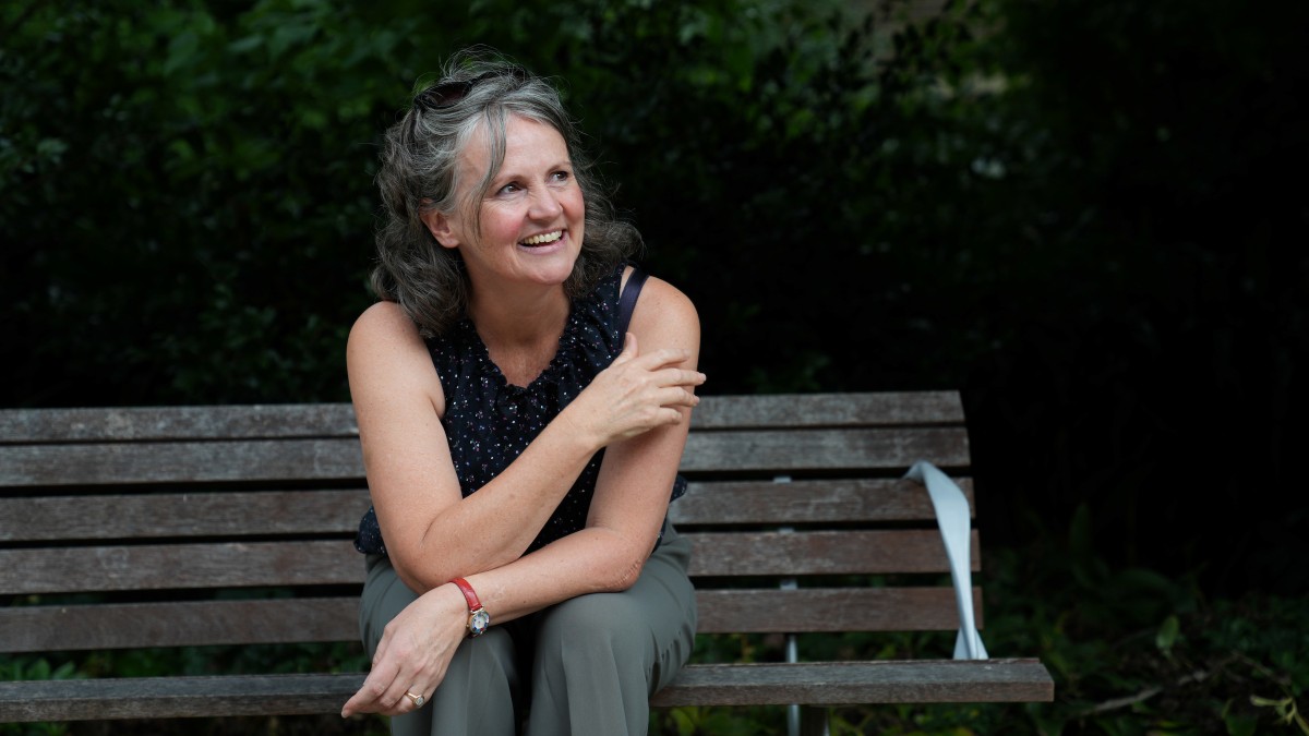 Sarah Mann sits outside on a park bench.