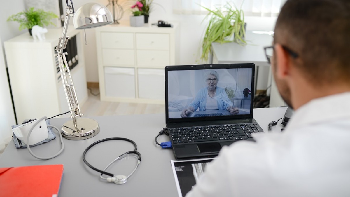 Man at computer talking to patient via video call