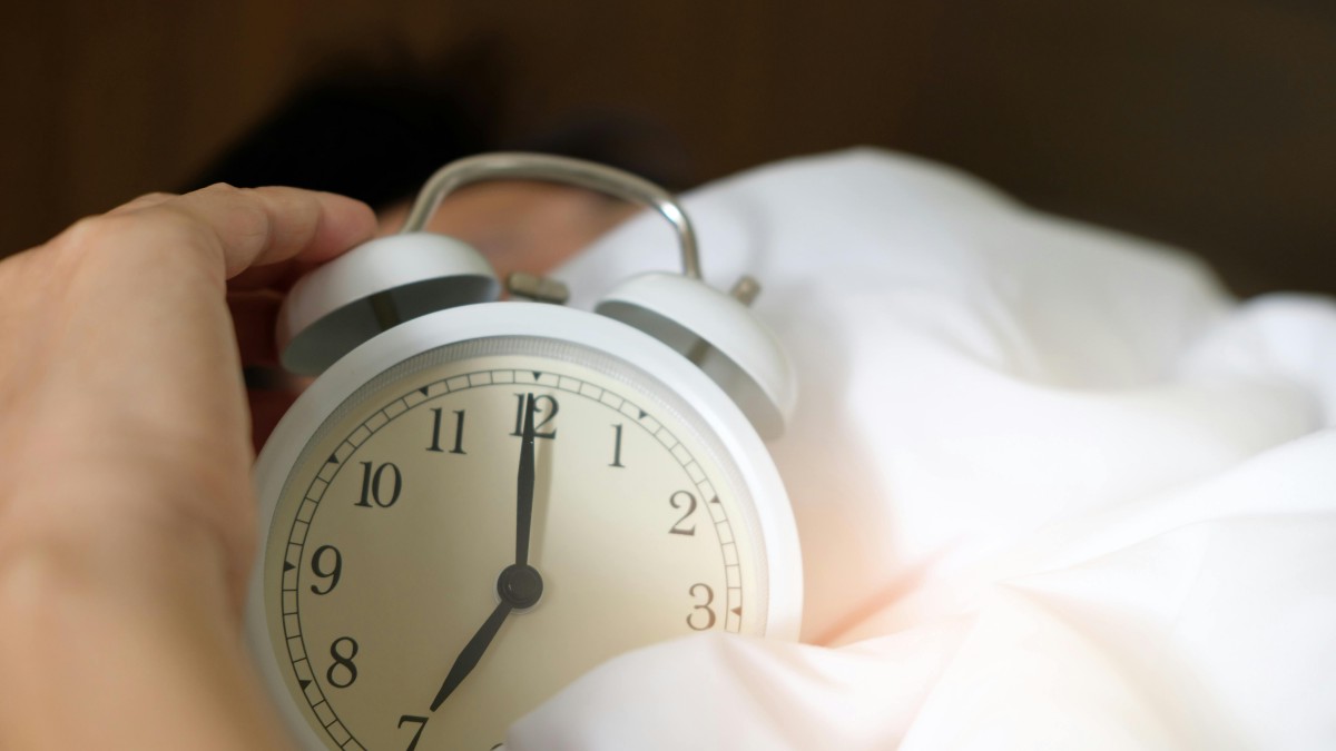 Photo of a person holding an alarm clock
