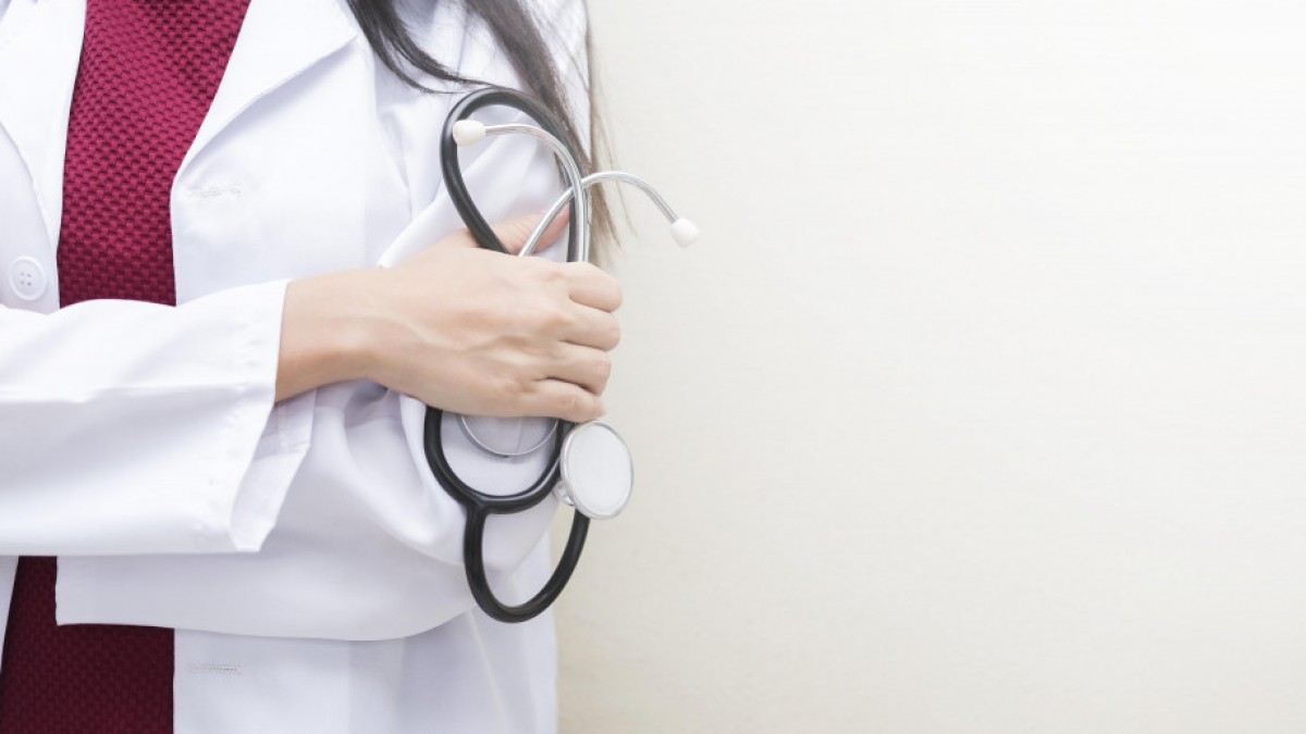 A close up of a doctor&#039;s hand holding a stethoscope.