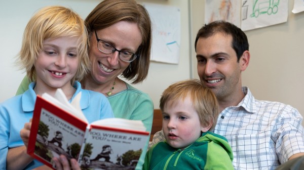 Family reading a children's book together.